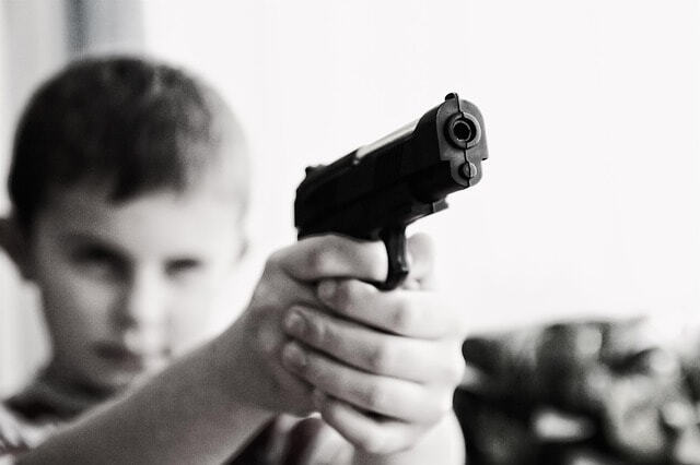 Chlapec na obrázku drží pistoli